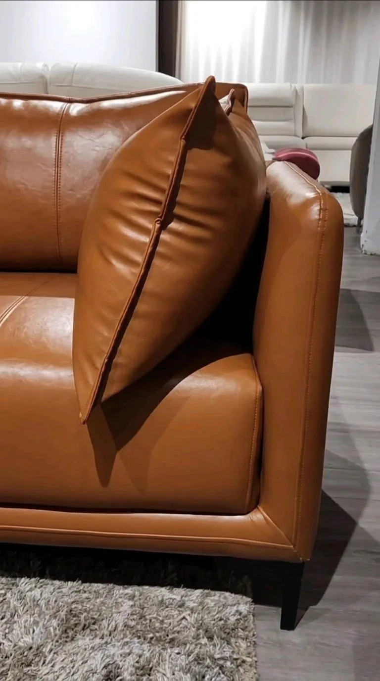 Tan leather sofa with bolster cushion after recolour and conditioning